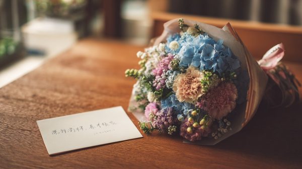A wrapped graduation bouquet with a handwritten blessing card.