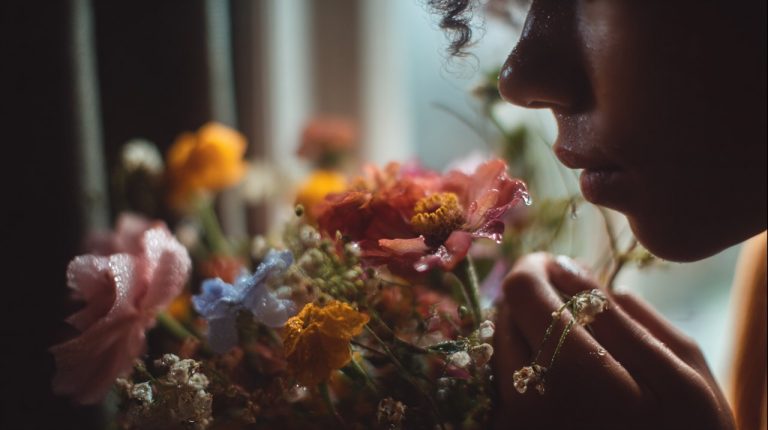 A person contemplating a vibrant bouquet of flowers.